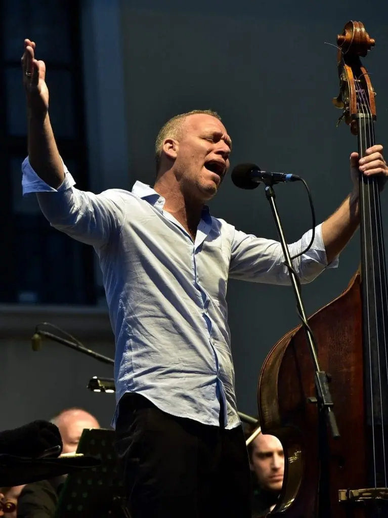 Avishai Cohen singing into microphone