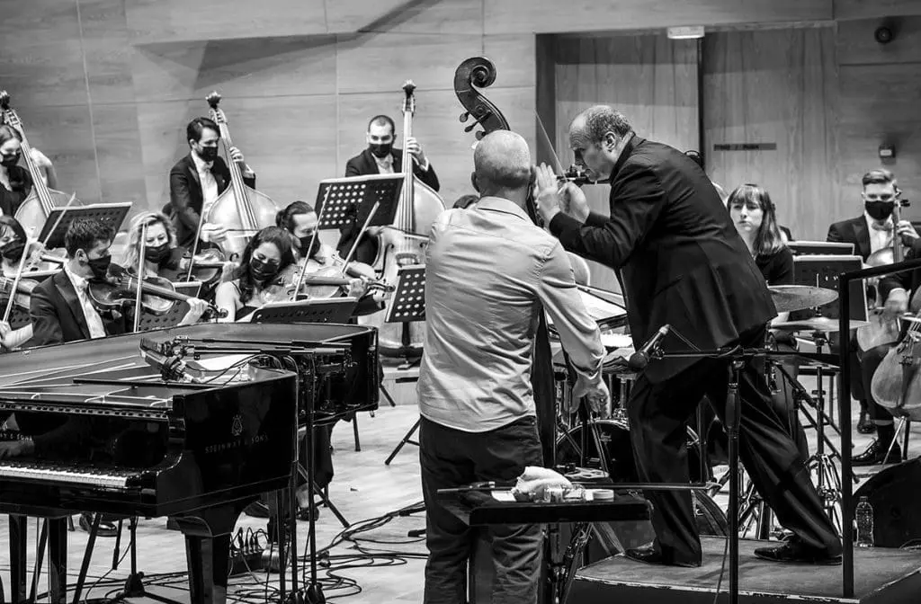 Orchestral show 2021 - Avishai Cohen with Conductor on stage (black and white)